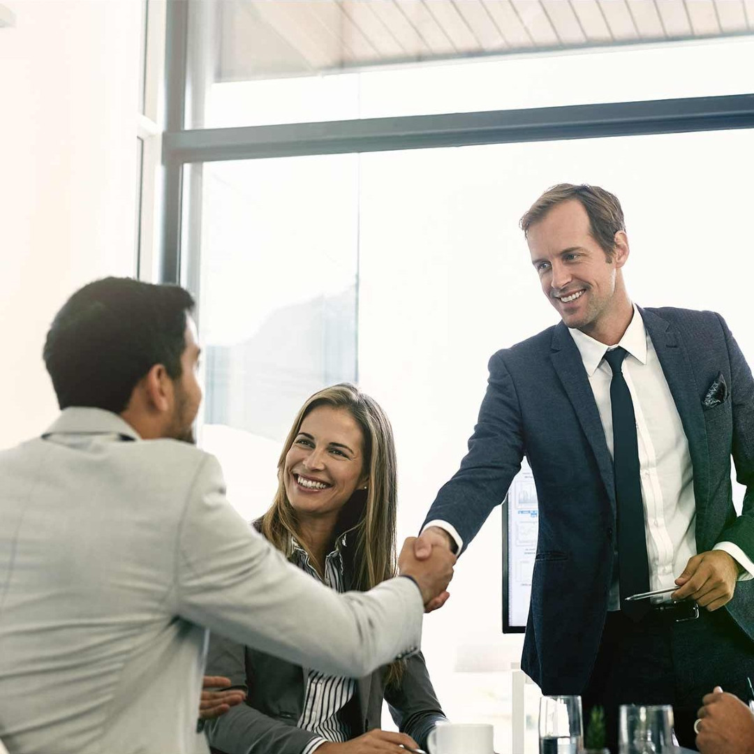 Picture of coworkers in a meeting and shaking hands