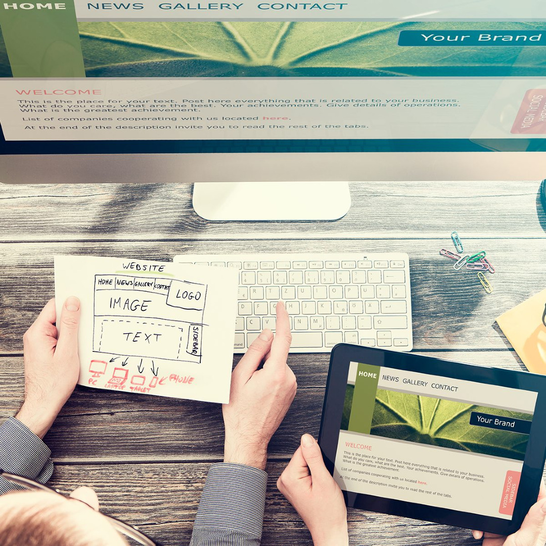 Picture of people going over a website layout with a computer and tablet