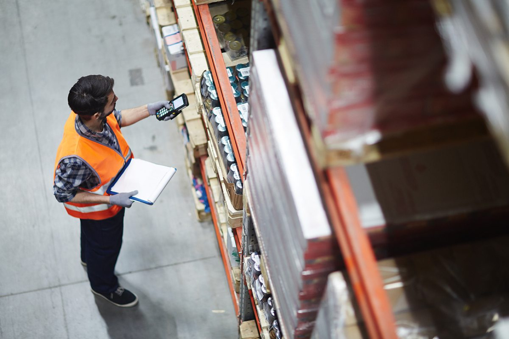 Picture of a warehouse worker scanning packages on shelves