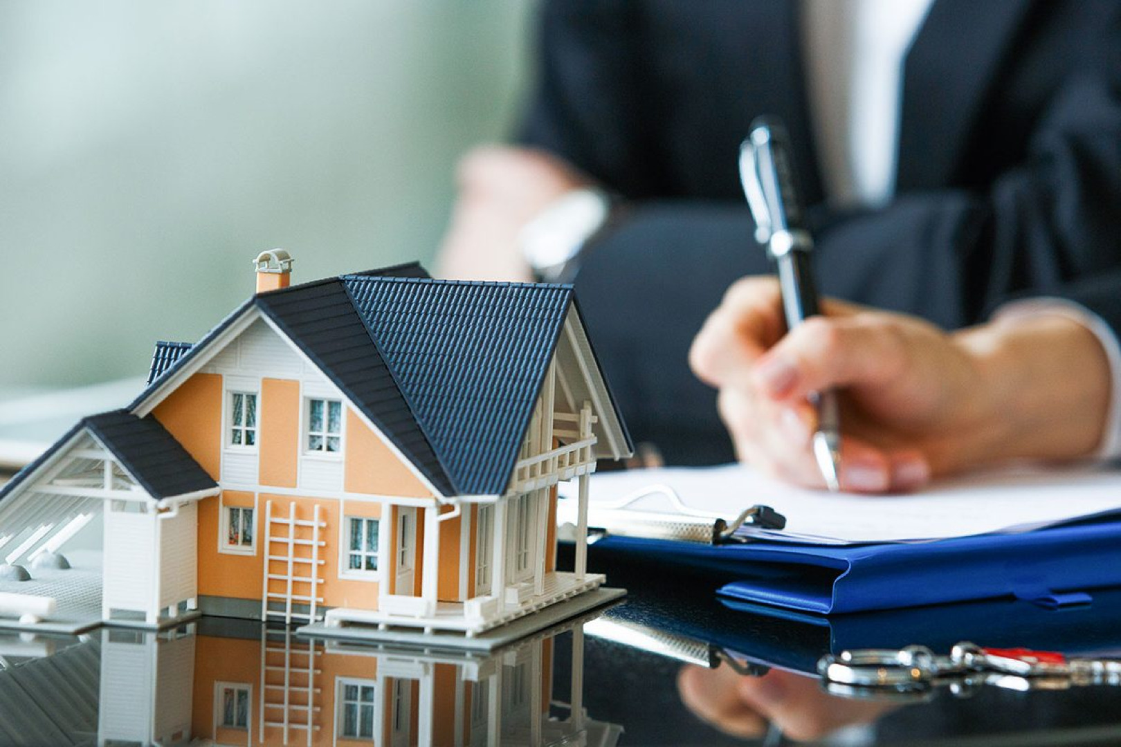 Picture of people at a meeting with a small model house on the table