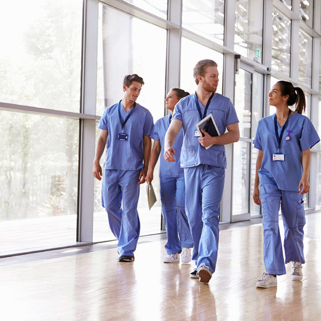 Picture of multiple health care professionals walking down a hallway